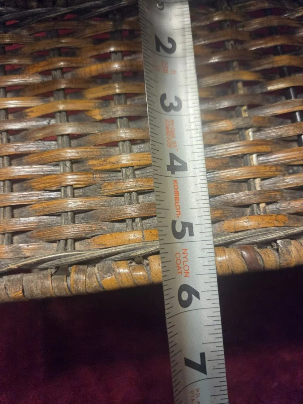 two tier wicker shelf with metal frame adorned with scrollwork some wear